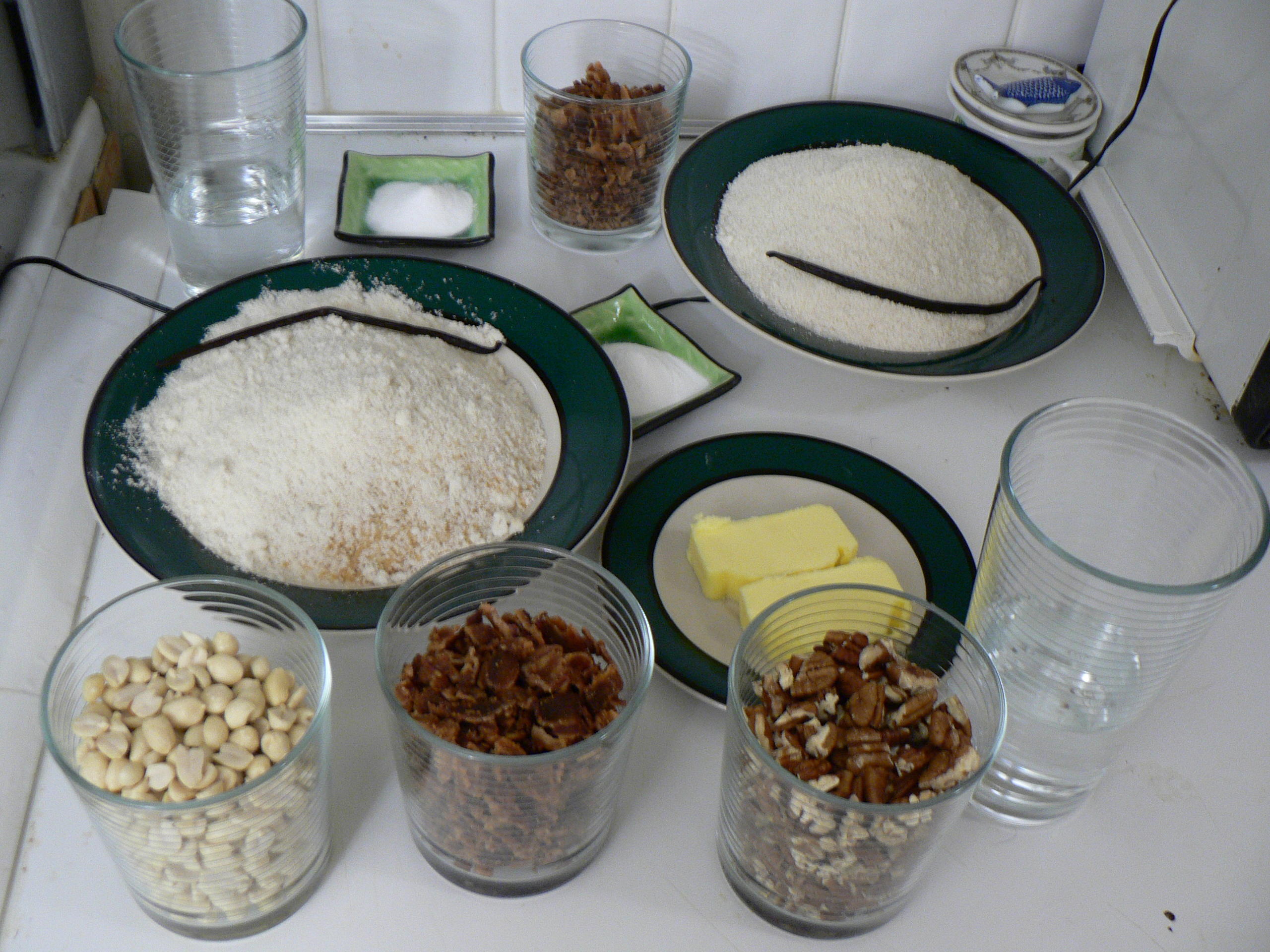 Mise en place for a recipe: flour, chopped nuts, butter and water measured into bowls and glasses before cooking